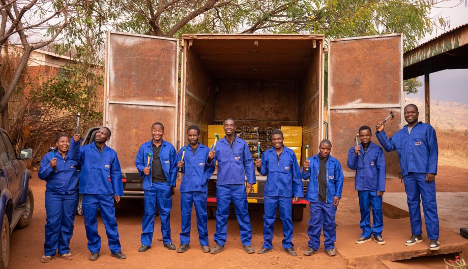 Solar lifht technicians stand in front of their van.