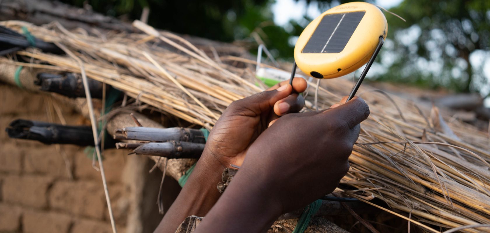 Eness Naliwa, places a solar light onto her roof so it can charge