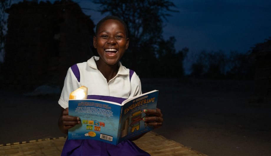 Fabriola uses her solar light to read at night