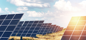 Solar panels in a solar farm, with clouds in the background.