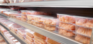 A supermarket self with packs of chicken meat.