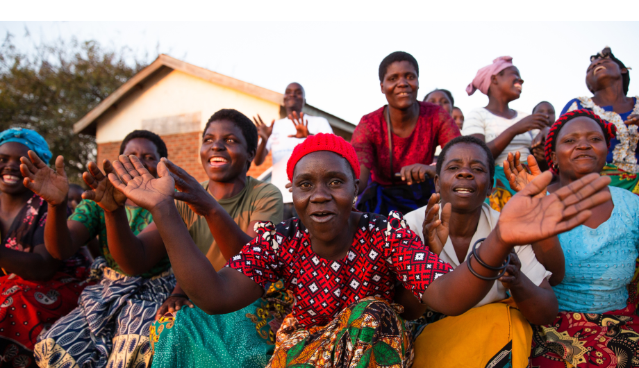 Women from the Chilima Mgwilizano Mayi Walas group in Malawi are dancing and celebrating together.