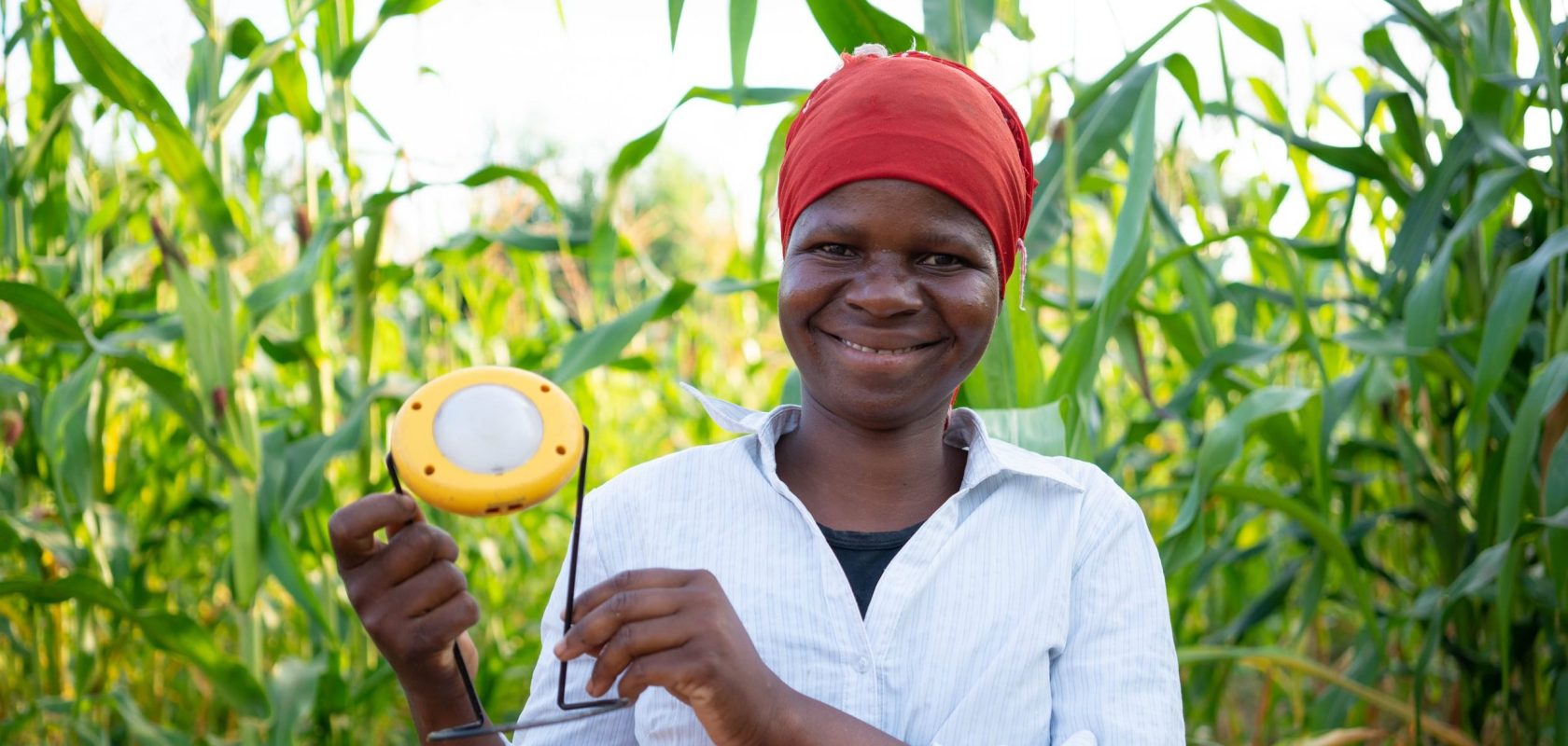 Liness Friday holds her solar light proudly and looks to camera.