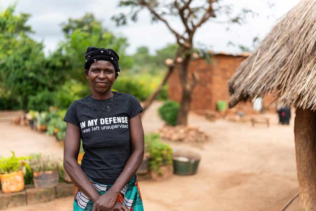 Fridah Luputa Mwale standing outside her home in Chipungu village, Zambia.